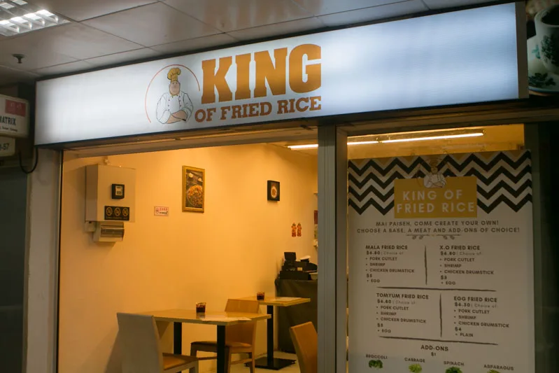 The original King of Fried Rice stall at Golden Mile Tower, with its lit signboard and hand-lettered menu