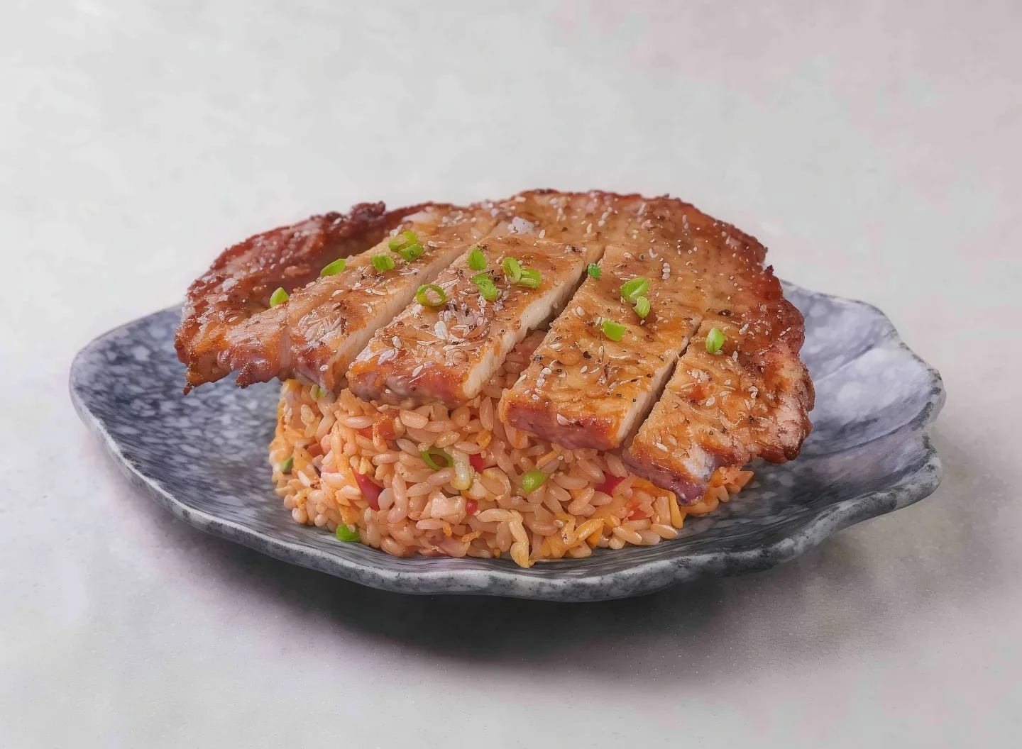Pork Cutlet Mala Fried Rice — sliced pork cutlet over chilli-red mala fried rice on a speckled plate