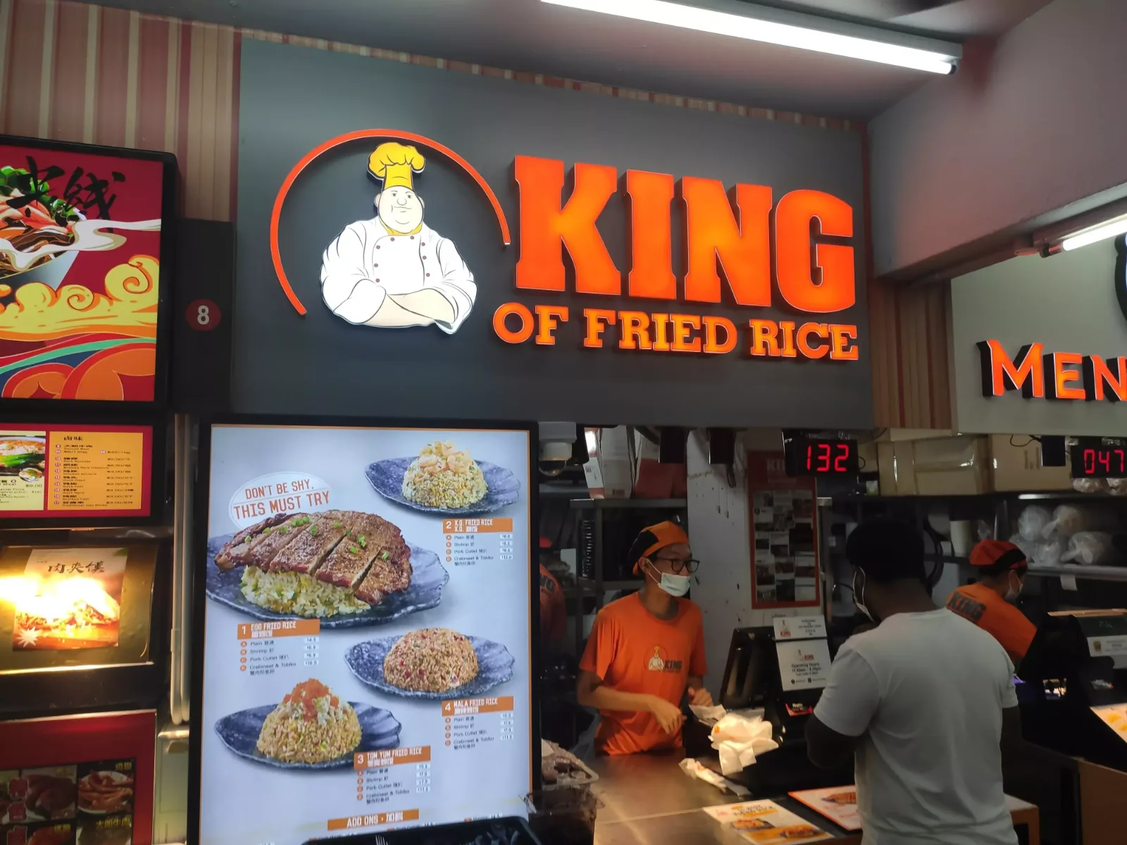 The illuminated King of Fried Rice signboard and crew at the Bendemeer Road coffeeshop stall