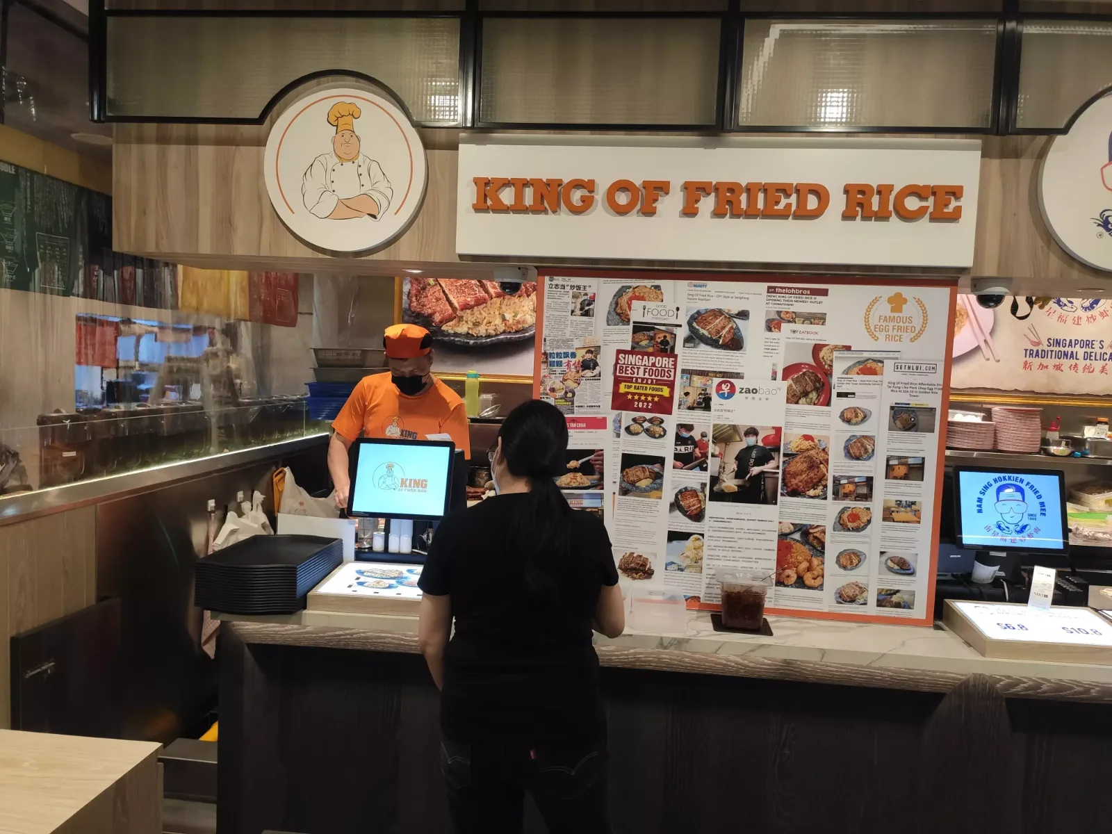 The King of Fried Rice counter at ION Orchard, with the chef-mascot roundel and a wall of press coverage